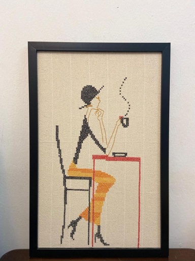 لوحة تطريز يدوي لامرأة أنيقة تحتسي القهوة